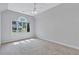 Bright bedroom with a large window, ceiling fan and neutral carpet at 5121 Hunters Hill Sw Cv, Lilburn, GA 30047