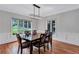 Formal dining room with hardwood floors, elegant chandelier, and views of the well landscaped yard at 5121 Hunters Hill Sw Cv, Lilburn, GA 30047