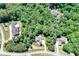 Aerial view of several homesites within a lush, heavily wooded community with mature trees at 8240 Hurakan Creek Xing, Cumming, GA 30028