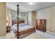 Bedroom features a four-poster bed, dresser, and carpet floors at 8240 Hurakan Creek Xing, Cumming, GA 30028