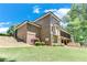 Landscaped backyard with a brick house and a screened porch surrounded by a lush green lawn at 8240 Hurakan Creek Xing, Cumming, GA 30028