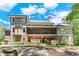 Expansive backyard of a brick home with a covered porch, outdoor kitchen, and lush greenery at 8240 Hurakan Creek Xing, Cumming, GA 30028