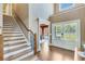 Inviting foyer with hardwood floors, staircase, and double doors leading to the outside at 8240 Hurakan Creek Xing, Cumming, GA 30028