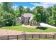 Charming brick home with a well-manicured front lawn, mature trees, and a circular driveway at 8240 Hurakan Creek Xing, Cumming, GA 30028