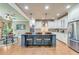 Bright kitchen with custom cabinetry, an island with seating, stainless steel appliances, and hardwood flooring at 8240 Hurakan Creek Xing, Cumming, GA 30028