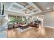 Open-concept living room with hardwood floors, coffered ceilings, fireplace, and natural light at 8240 Hurakan Creek Xing, Cumming, GA 30028