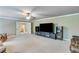 Spacious living room featuring a ceiling fan and entertainment center with large TV screen at 8240 Hurakan Creek Xing, Cumming, GA 30028