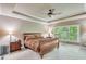 Comfortable main bedroom featuring tray ceilings and lots of natural light at 8240 Hurakan Creek Xing, Cumming, GA 30028