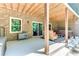 Outdoor patio featuring exposed wood rafters, brick columns, a hot tub, and comfortable wicker seating at 8240 Hurakan Creek Xing, Cumming, GA 30028