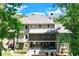 Lovely rear exterior featuring a screened porch, patio area with a hot tub, and wooded surroundings at 8240 Hurakan Creek Xing, Cumming, GA 30028