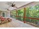 Inviting screened-in porch with wood floors, ceiling fans, and beautiful views of lush greenery at 8240 Hurakan Creek Xing, Cumming, GA 30028