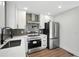 A modern kitchen featuring stainless steel appliances, white cabinets, and sleek countertops at 1227 Kenilworth Dr, Atlanta, GA 30310