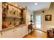 Home bar area featuring granite countertops, shelving for glassware and liquor, and hardwood floors at 8480 Valemont Dr, Sandy Springs, GA 30350