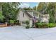 Charming home featuring a manicured yard, attached garage, and brick patio area with outdoor seating at 8480 Valemont Dr, Sandy Springs, GA 30350