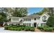 Beautiful two-story home with white painted brick, manicured landscaping and an American flag at 8480 Valemont Dr, Sandy Springs, GA 30350