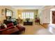 Cozy living room featuring hardwood floors, a piano, comfortable seating, and plantation shutters at 8480 Valemont Dr, Sandy Springs, GA 30350