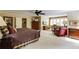 Large main bedroom featuring a ceiling fan, plush seating, and an attached home office at 8480 Valemont Dr, Sandy Springs, GA 30350