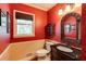 Well-decorated powder room with bright red walls, decorative mirror, and pedestal sink at 8480 Valemont Dr, Sandy Springs, GA 30350