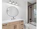 Modern bathroom boasting a round mirror, white countertop, and a glass-enclosed shower with tile accents at 915 Laurel Brooke Ave, Peachtree City, GA 30269