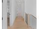 Well-lit hallway with wood flooring and minimalist design, creating a clean and open transition between rooms at 915 Laurel Brooke Ave, Peachtree City, GA 30269