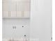 Laundry closet with white shaker cabinetry and gold hardware at 915 Laurel Brooke Ave, Peachtree City, GA 30269