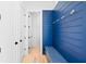 Mudroom featuring a blue accent wall with hooks, a bench with storage, and light hardwood floors at 915 Laurel Brooke Ave, Peachtree City, GA 30269