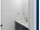 Powder room features marble countertops, dark blue vanity, and round gold mirror at 915 Laurel Brooke Ave, Peachtree City, GA 30269