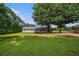 Expansive backyard featuring lush lawn, mature trees, and a covered patio area at 95 Oak Grove Cir, Mcdonough, GA 30253