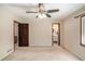 Bedroom with a ceiling fan, neutral walls, and carpet, next to an en-suite bathroom at 95 Oak Grove Cir, Mcdonough, GA 30253