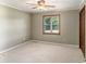 Cozy carpeted bedroom with a ceiling fan, natural light, and a wood-door closet at 95 Oak Grove Cir, Mcdonough, GA 30253