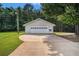 Detached two-car garage with a white door and a long concrete driveway at 95 Oak Grove Cir, Mcdonough, GA 30253