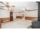 Open living room design features two ceiling fans, wainscoting, neutral carpet and a stone fireplace at 95 Oak Grove Cir, Mcdonough, GA 30253