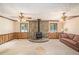 Spacious living room featuring a stone fireplace, wood paneling, vintage ceiling fans, and large windows at 95 Oak Grove Cir, Mcdonough, GA 30253
