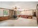 Bright living room featuring a stone fireplace, wood paneling, vintage ceiling fans, and large windows at 95 Oak Grove Cir, Mcdonough, GA 30253
