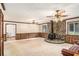 Spacious living room featuring a stone fireplace, wood paneling, and vintage ceiling fans at 95 Oak Grove Cir, Mcdonough, GA 30253