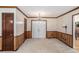 Spacious living room featuring neutral carpet, wainscoting, and a classic chandelier above the double door entryway at 95 Oak Grove Cir, Mcdonough, GA 30253