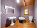 Bathroom with dark purple walls, wood floors, sink, mirror, toilet, and bathtub at 1975 Mack Rd, Douglasville, GA 30135