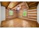 Bedroom featuring wood-paneled walls and hardwood floors plus two windows at 1975 Mack Rd, Douglasville, GA 30135