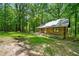 Secluded log cabin with a welcoming porch and a forest backdrop, creating a tranquil, rustic atmosphere at 1975 Mack Rd, Douglasville, GA 30135