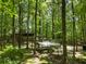 Serene, wooded landscape featuring a log cabin and car port nestled amongst the trees at 1975 Mack Rd, Douglasville, GA 30135