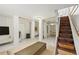 Finished basement with exposed support beams, entertainment area, and wood stairs at 240 W Lake Nw Dr, Atlanta, GA 30314