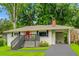 Charming single story home featuring a pink front door, a carport, and mature trees at 240 W Lake Nw Dr, Atlanta, GA 30314