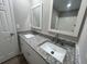 Bathroom with double vanity featuring white cabinets and granite countertops at 5961 Sherwood Trce, Stonecrest, GA 30038