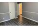 A bedroom with gray walls, white trim, and dark-colored wood flooring at 6471 Ansley Blvd, Lithia Springs, GA 30122