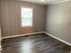A bedroom with gray plank walls, white trim, and dark-colored wood flooring at 6471 Ansley Blvd, Lithia Springs, GA 30122