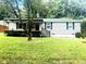 Charming single-story home with vinyl siding, mature trees, and a well-maintained front lawn at 6471 Ansley Blvd, Lithia Springs, GA 30122