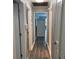 Hallway leading to a kitchen featuring gray plank walls and dark-colored wood flooring at 6471 Ansley Blvd, Lithia Springs, GA 30122