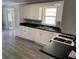 Renovated kitchen boasts white cabinetry, black countertops and modern vinyl flooring at 6471 Ansley Blvd, Lithia Springs, GA 30122