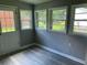 Sunroom featuring gray plank walls, windows for natural light, and a door leading to the backyard at 6471 Ansley Blvd, Lithia Springs, GA 30122