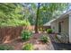 Exterior view of backyard with bench, mulch beds, trees and partial fence, offering an inviting outdoor space at 1901 Brittania Cir, Woodstock, GA 30188